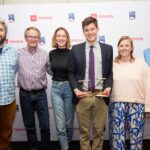 NYSEF ski jumping coach poses with NYSEF staff at award ceremony